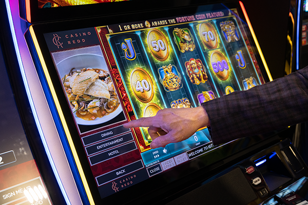 Hand interacting with pop out food ordering tab while playing IGT slot games