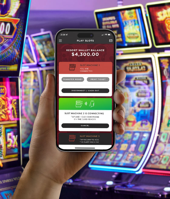 A person holding a smartphone in a casino featuring the IGT Advantage Cardless Connect casino patron mobile app